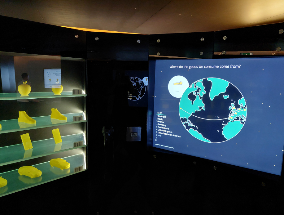 Image showing 3D-printed items left, a big screen right, and a barcode scanner in the middle.
